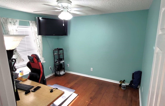 office space with baseboards, a textured ceiling, ceiling fan, and wood finished floors