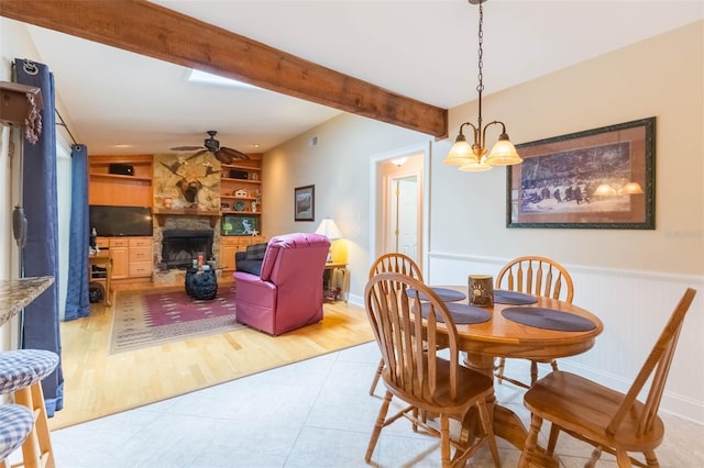 3714 Village Estates Pl, Tampa, FL 33618 - dining space featuring ceiling fan with notable chandelier, a wainscoted wall, built in shelves, a fireplace, and beamed ceiling