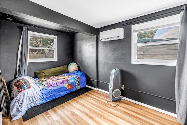 bedroom featuring an AC wall unit and wood finished floors