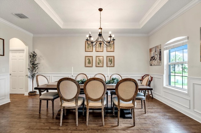 dining space with an inviting chandelier, ornamental molding, dark wood-style flooring, and visible vents