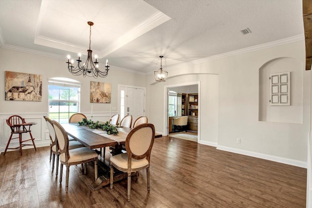 dining area featuring crown molding, dark wood-style flooring, a chandelier, and visible vents