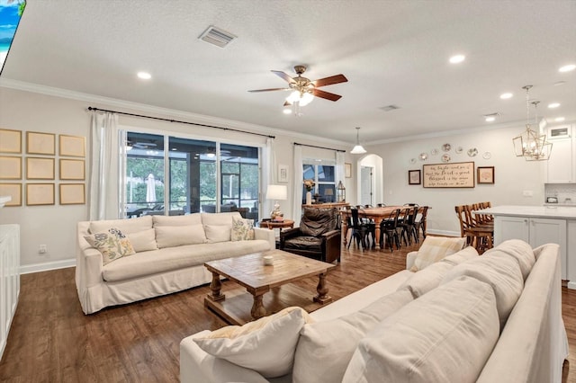 living room featuring arched walkways, a ceiling fan, dark wood finished floors, and visible vents