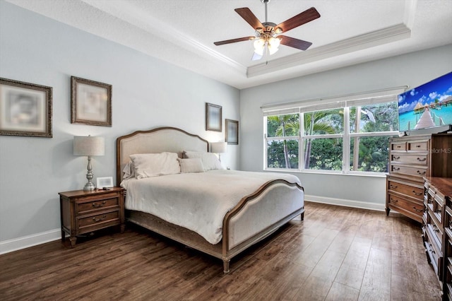 bedroom with a raised ceiling, baseboards, ornamental molding, and dark wood-type flooring
