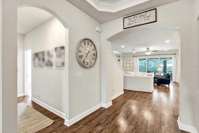 hall featuring arched walkways, baseboards, dark wood finished floors, and recessed lighting
