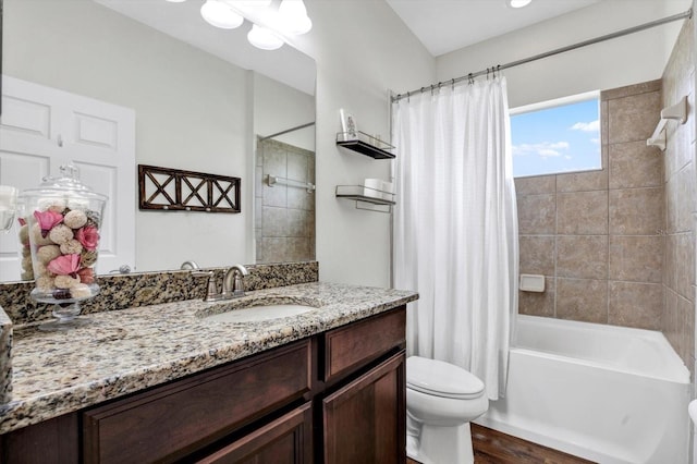 bathroom with vanity, toilet, wood finished floors, and shower / bath combo with shower curtain