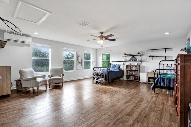 interior space with multiple windows, a wall unit AC, attic access, and wood finished floors