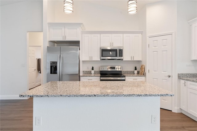 14404 SW 19th Pl, Ocala, FL 34481 - kitchen with appliances with stainless steel finishes, a center island, white cabinetry, light stone counters, and light wood-style flooring
