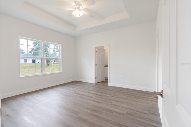 14404 SW 19th Pl, Ocala, FL 34481 - unfurnished room with baseboards, a ceiling fan, wood finished floors, and a tray ceiling
