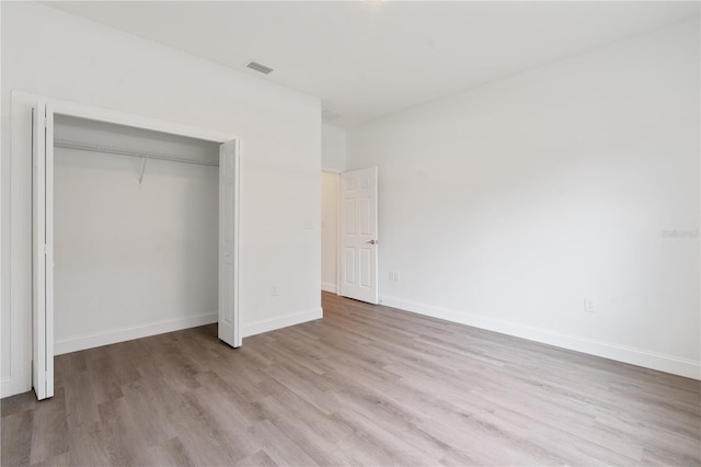 14404 SW 19th Pl, Ocala, FL 34481 - unfurnished bedroom with a closet, baseboards, wood finished floors, and visible vents
