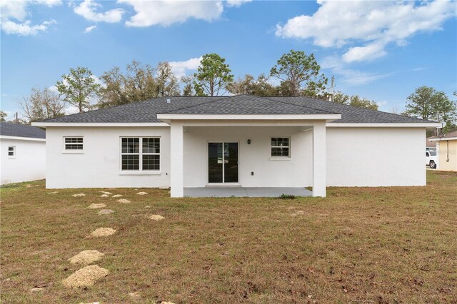 14404 SW 19th Pl, Ocala, FL 34481 - rear view of property featuring a yard, a patio, a shingled roof, and stucco siding