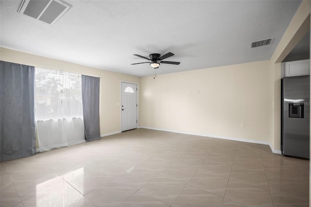 unfurnished living room featuring ceiling fan, visible vents, and baseboards