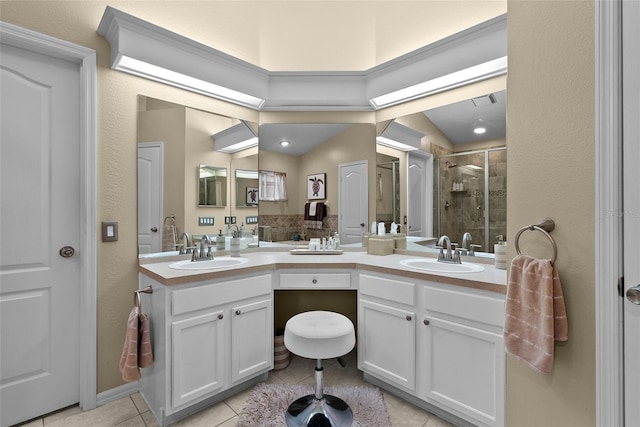 bathroom with tile patterned flooring, a sink, double vanity, and a shower stall