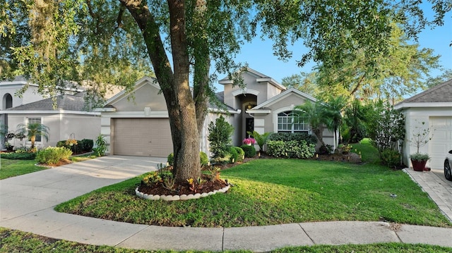 view of front of home with stucco siding, a garage, driveway, and a front lawn