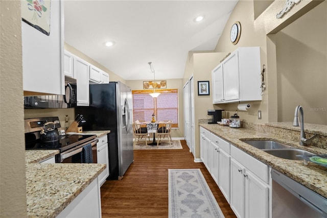 kitchen with appliances with stainless steel finishes, a sink, dark wood-style floors, lofted ceiling, and white cabinetry