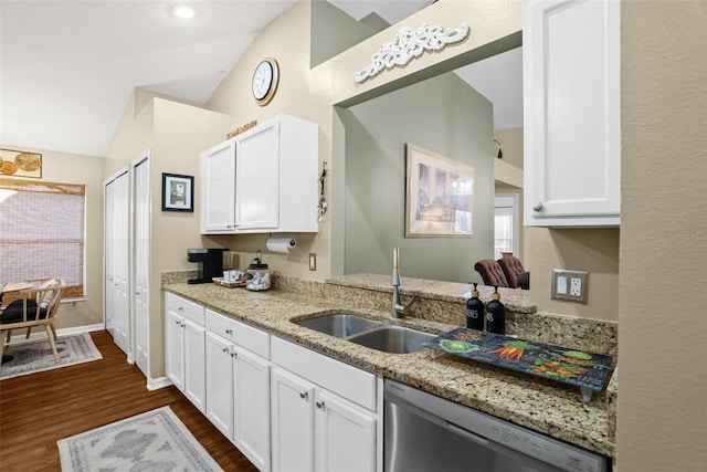 kitchen featuring dark wood-type flooring, white cabinetry, a sink, dishwasher, and vaulted ceiling