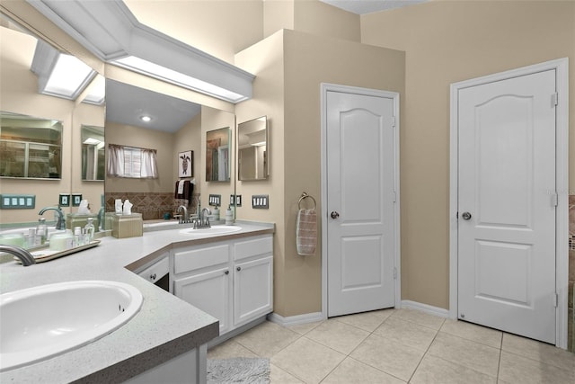 full bathroom featuring tile patterned flooring, a sink, baseboards, and double vanity