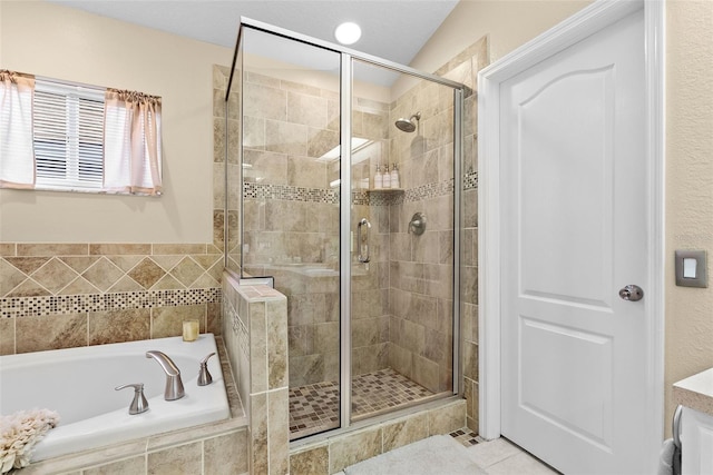 bathroom featuring tile patterned flooring, a garden tub, and a stall shower