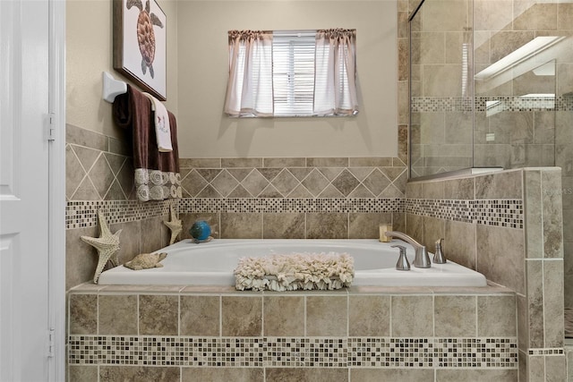 full bathroom with a garden tub and tiled shower