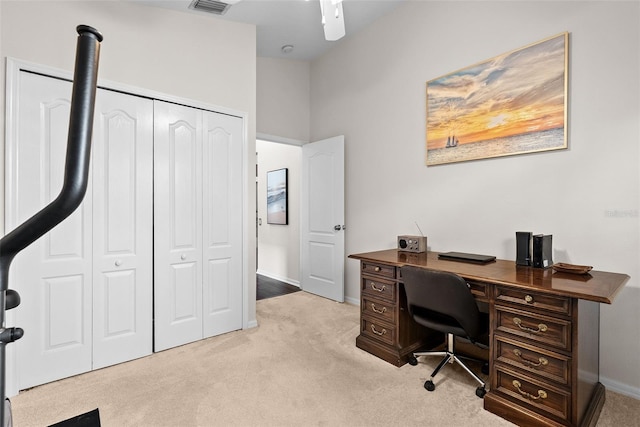 office space featuring baseboards, visible vents, and light colored carpet