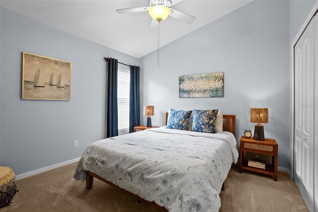 carpeted bedroom with a ceiling fan, baseboards, lofted ceiling, and a closet
