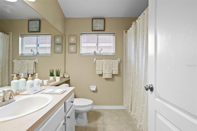 full bathroom with tile patterned flooring, a wealth of natural light, toilet, and vanity