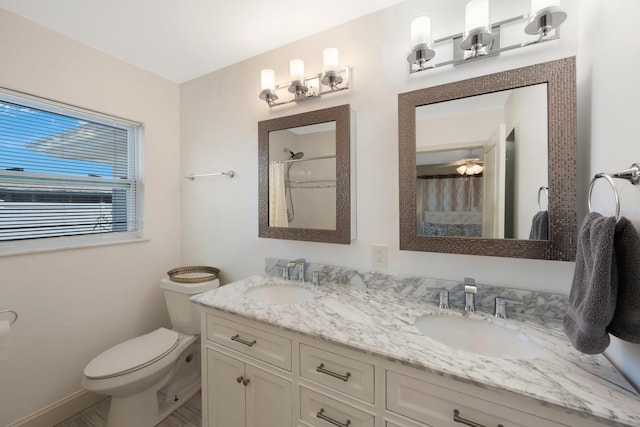 bathroom featuring a sink, curtained shower, toilet, and double vanity