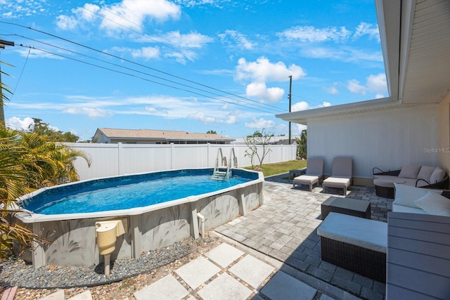 view of swimming pool with an outdoor living space, a fenced backyard, a fenced in pool, and a patio