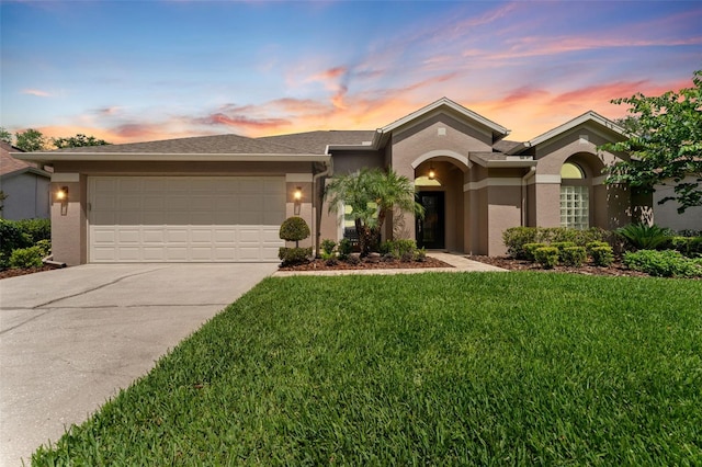 view of front facade featuring concrete driveway, stucco siding, a front yard, and a garage