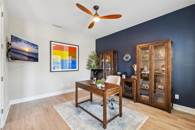 office with baseboards, ceiling fan, light wood-type flooring, and visible vents