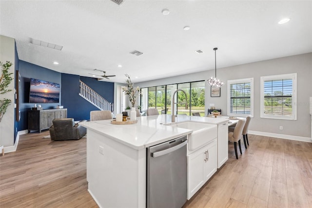 kitchen featuring visible vents, light wood-style floors, open floor plan, a sink, and dishwasher