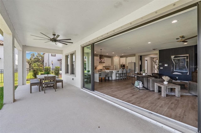 view of patio / terrace with fence, a ceiling fan, outdoor dining area, and an outdoor living space