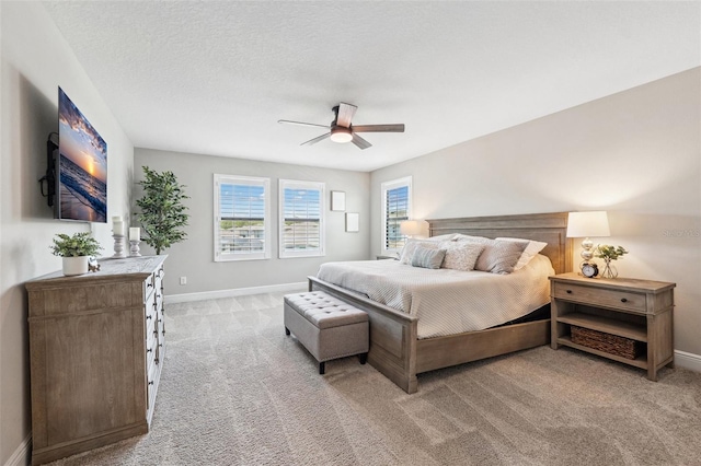 bedroom with baseboards, ceiling fan, and light carpet