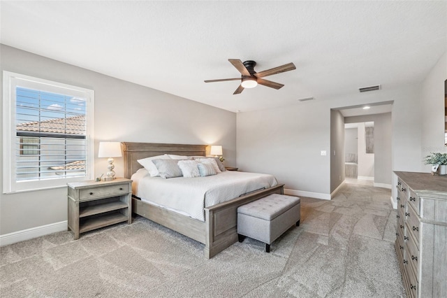 bedroom with baseboards, ceiling fan, light colored carpet, and visible vents