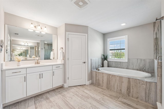 bathroom featuring vanity, a stall shower, a bath, and visible vents
