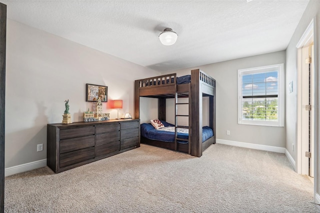 bedroom with baseboards, carpet flooring, and a textured ceiling