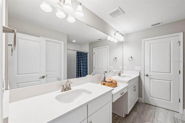 bathroom featuring visible vents, an inviting chandelier, curtained shower, and vanity