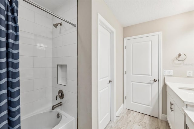 bathroom featuring vanity, baseboards, and shower / bath combo