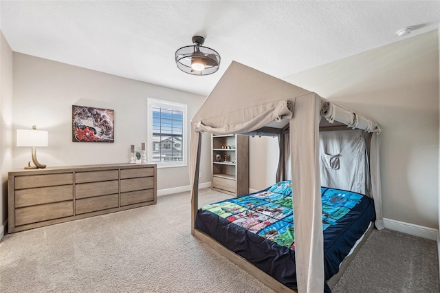 carpeted bedroom featuring a textured ceiling and baseboards