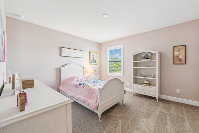 bedroom with baseboards and light carpet