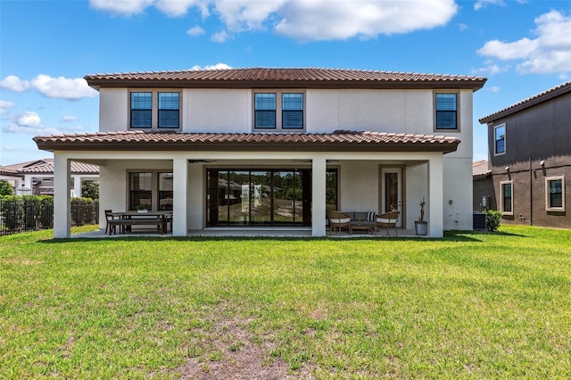back of house featuring a lawn, a patio, and stucco siding
