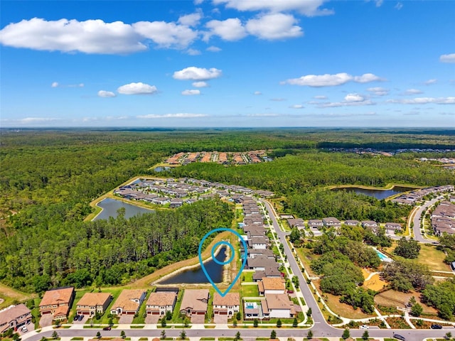 birds eye view of property featuring a water view, a residential view, and a wooded view