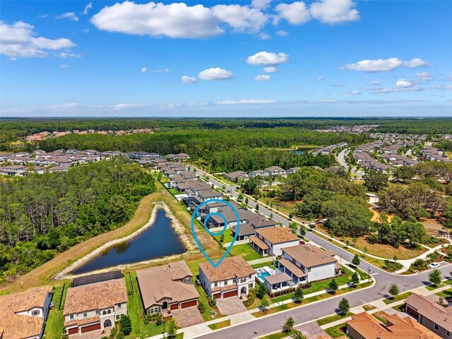 aerial view featuring a water view, a view of trees, and a residential view
