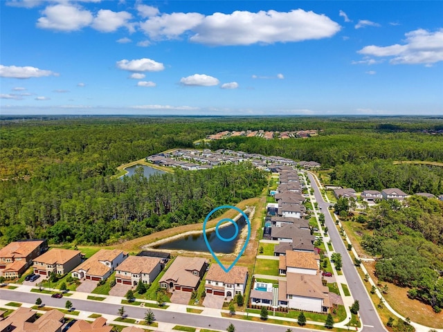 bird's eye view featuring a residential view, a water view, and a wooded view