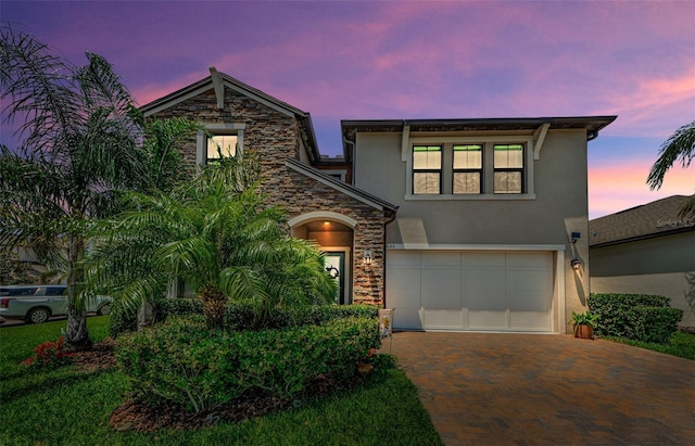 2653 Longleaf Pine Pt, New Port Richey, FL 34655 - view of front of house with stucco siding, decorative driveway, stone siding, and a garage