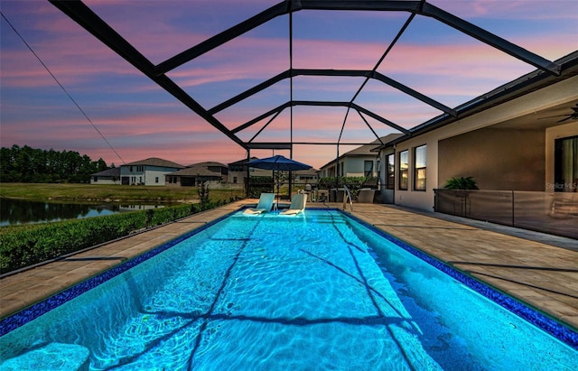 2653 Longleaf Pine Pt, New Port Richey, FL 34655 - pool at dusk with an outdoor pool, a water view, a patio area, and ceiling fan