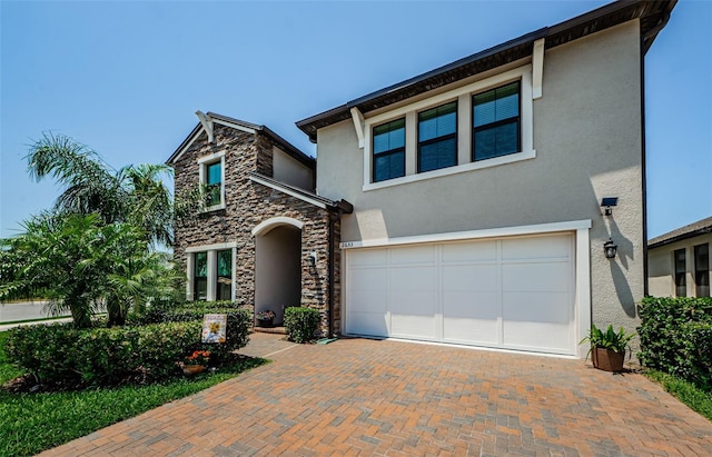 2653 Longleaf Pine Pt, New Port Richey, FL 34655 - view of front of home featuring stucco siding, stone siding, decorative driveway, and a garage