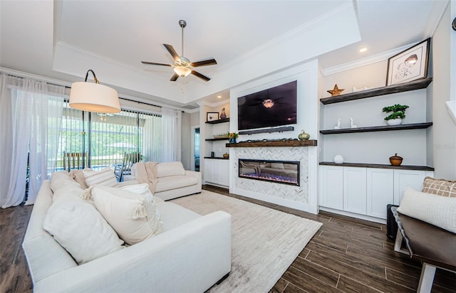 2653 Longleaf Pine Pt, New Port Richey, FL 34655 - living area featuring a raised ceiling, dark wood finished floors, crown molding, a ceiling fan, and a tiled fireplace