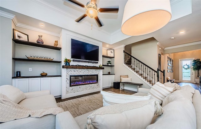 2653 Longleaf Pine Pt, New Port Richey, FL 34655 - living area featuring wood finished floors, ornamental molding, stairway, a ceiling fan, and a glass covered fireplace