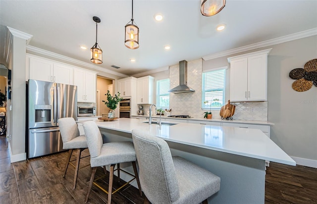 2653 Longleaf Pine Pt, New Port Richey, FL 34655 - kitchen with stainless steel appliances, wall chimney range hood, dark wood finished floors, an island with sink, and crown molding