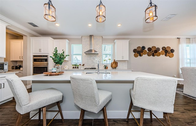 2653 Longleaf Pine Pt, New Port Richey, FL 34655 - kitchen featuring wall chimney range hood, stainless steel double oven, light countertops, decorative backsplash, and ornamental molding